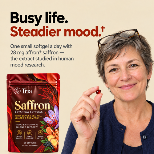 Woman holding a Tria Saffron softgel - busy life, steadier mood