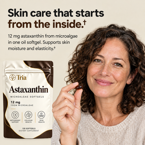 Woman holding a Tria Astaxanthin softgel - skin care that starts from the inside